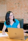 woman in teal t-shirt sitting beside woman in suit jacket